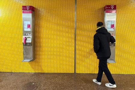 Zwei Wandtelefone am Bochumer Hauptbahnhof - mancher Passant bleibt stehen und blickt verwundert auf die alte Technik.