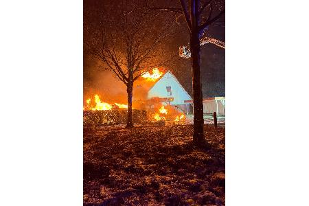 PKWs und Gebäude in Brand