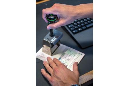 Symbolbild der Bundespolizei, manuelle Stempelung eines Reisepasses