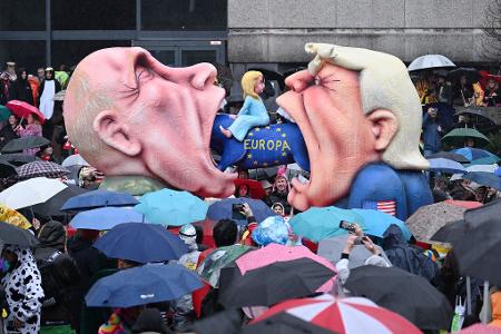 Ein Mottowagen mit Putin und Trump, die versuchen Europa zu fressen, fährt an den Zuschauern beim Rosenmontagszug in Düsseldorf vorbei. 