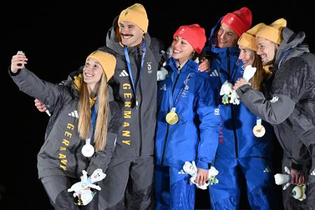 Tabitha Stoecker (Großbritannien) und Matt Weston (Großbritannien, beide M) posieren bei der Siegerehrung ihren Goldmedaillen nach dem Skeleton-Team-Wettbewerb neben Susanne Kreher (Deutschland, l) und Axel Jungk (Deutschland, 2.v.l.) mit der Silbermedaille und Jacqueline Pfeifer (Deutschland, 2.v.r.) und Christopher Grotheer (Deutschland) mit der Bronzemedaille bei den Olympischen Winterspielen Mailand Cortina 2026.