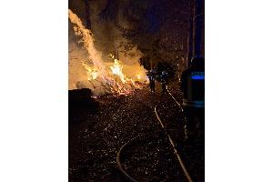 Die Feuerwehr löscht das brennende Feuerholz