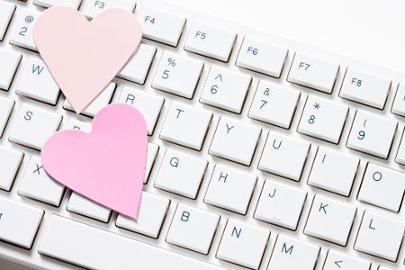 Auf einer Tastatur liegen zwei rosa Herzchen