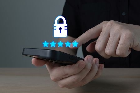 Mann hat Handy in der Hand, aus dem ein virtuelles Sicherheitsschloss aufsteigt