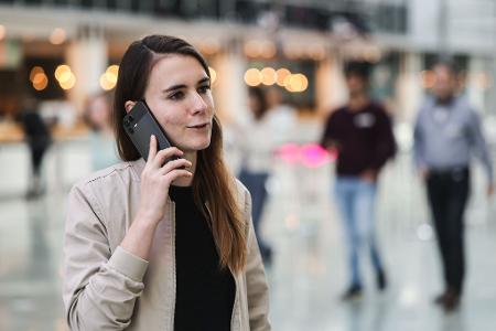 Die für KI zuständige Telekom-Mitarbeiterin Lena Drubel führt bei einer Testvorführung des KI-Assistenten ein Handytelefonat.