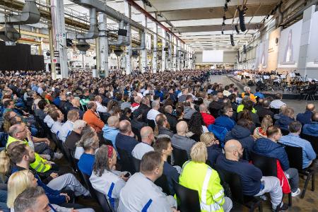 Tausende Mitarbeiterinnen und Mitarbeiter folgen der Versammlung in Halle 11 des Stammwerks.