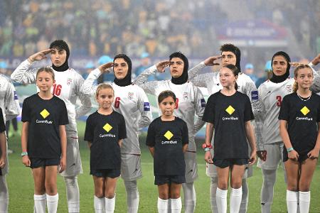 Iranische Fußballerinnen salutieren bei der Nationalhymne vor dem Spiel gegen Australien.
