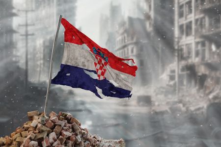 Zerfetzte Kroatienflagge vor dem Hintergrund von undeutlichen Ruinen