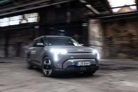 Kia EV3 58,3 kWh fährt in einer Industriehalle mit eingeschaltetem LED-Tagfahrlicht.