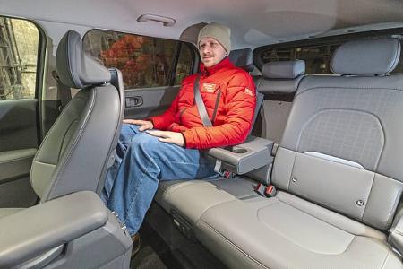 Innenraumaufnahme des Kia EV3 58,3 kWh, Rücksitzbank mit Testperson.