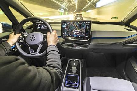 Innenraumaufnahme eines VW ID.3 52 kWh während der Fahrt, Fokus auf Cockpit, Lenkrad und Infotainmentsystem.