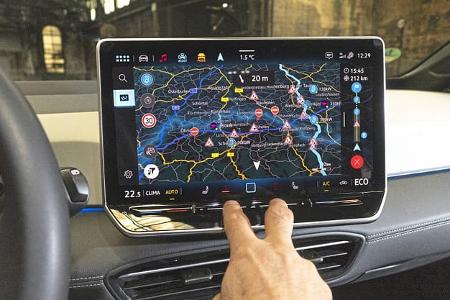 Innenraumaufnahme eines VW ID.3 52 kWh, Fokus auf das zentrale Infotainment-Display mit Navigationssystem, Hand bedient Touchscreen.