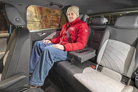 Innenraumaufnahme eines VW ID.3 52 kWh mit einer Person auf der Rückbank. Die Aufnahme zeigt die Beinfreiheit und Sitzposition im Fond.