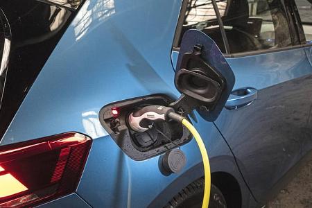 Detailaufnahme eines blauen VW ID.3 52 kWh beim Ladevorgang an einer Ladesäule in einer Halle. Das Ladekabel ist an der Ladebuchse angeschlossen, der Fokus liegt auf dem hinteren Fahrzeugbereich.