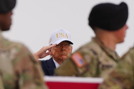 US-Präsident Donald Trump salutiert hinter einer mit der US-Flagge bedeckte Transportkiste mit den sterblichen Überresten eines US-Soldaten, der bei einem iranischen Drohnenangriff auf eine Kommandozentrale in Kuwait getötet wurde.