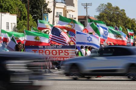 Autos fahren in Los Angeles an Demonstranten vorbei.
