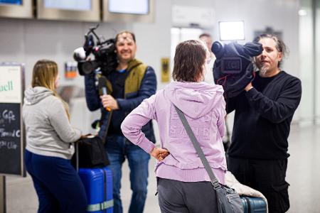Dubai-Touristen geben nach ihrer Landung Kameramännern Interviews.