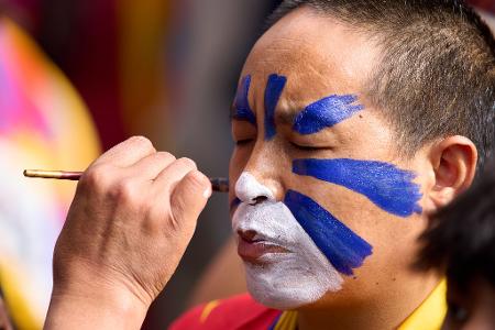 Jahrestag des Aufstandes gegen die chinesische Besatzung in Tibet: Ein tibetischer Mönch im Exil lässt sein Gesicht in einem Tempel in Indien in den tibetischen Farben bemalen.
