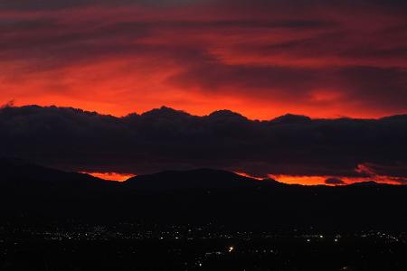 Die untergehende Sonne beleuchtet eine Wolkenbank, die über den Rocky Mountains schwebt, während ein Sturm über die Front Range von Colorado fegt.