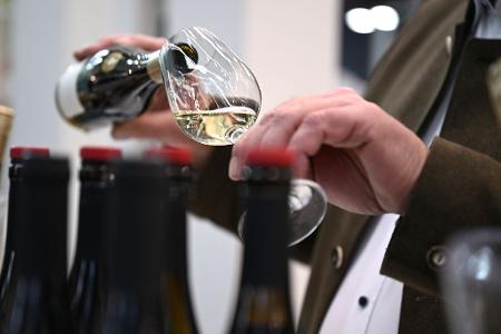 Ein Mitarbeiter des badischen Weinguts Bimmerle gießt am Prowein-Messe-Stand seiner Firma Riesling in ein Glas.