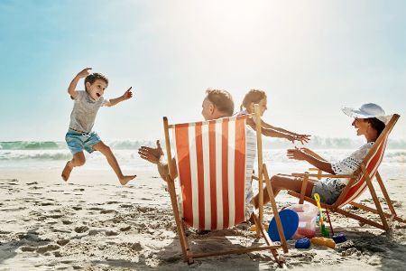 Familie in Liegestühlen am Strand