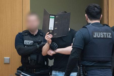 Zwei der Männer verdeckten beim Betreten des Gerichtssaals ihr Gesicht.