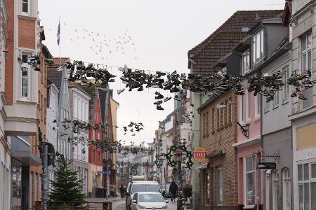 Schuhe hängen auf einer Leine über einer Straße