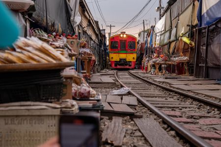 Zug fährt durch einen Markt in Thailand