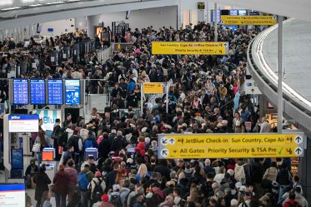Passagiere warten in einer TSA-Schlange.