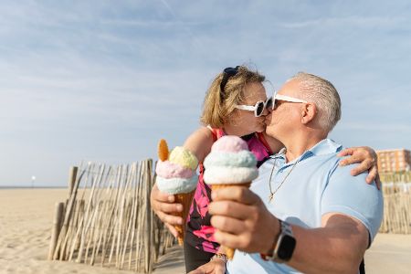 Altes Ehepaar isst am Strand Eis