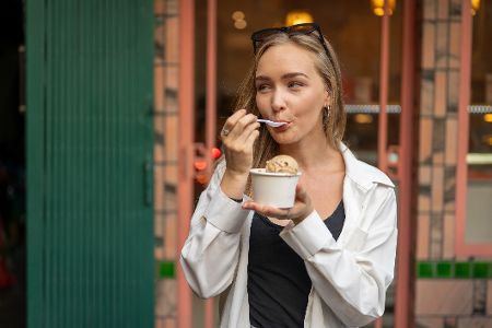 Junge Frau isst Eis aus einem Becher