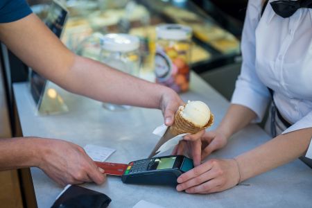 Besucher eines Eiscafés zahlt mit Karte