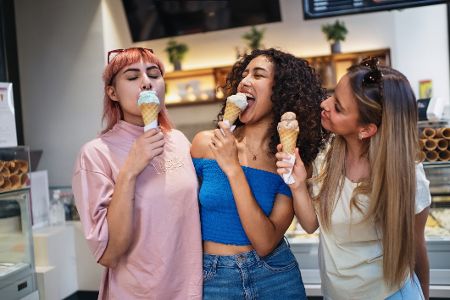 Drei junge Frauen essen Eis in einer Eisdiele