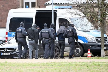 Zwei mutmaßliche Hamas-Mitglieder werden von Polizisten bei einem Hubschrauberlandeplatz von einem Hubschrauber zu einem Auto geführt. (Archivbild)