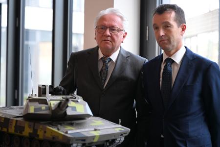 Papperger und Escribano bei einem Modell des Rheinmetall-Kampfpanzers Panther.