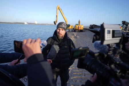 Robert Marc Lehmann spricht mit den Medien am Strand, in dessen Nähe der gestrandete Buckelwal im Wasser gelegen hatte.