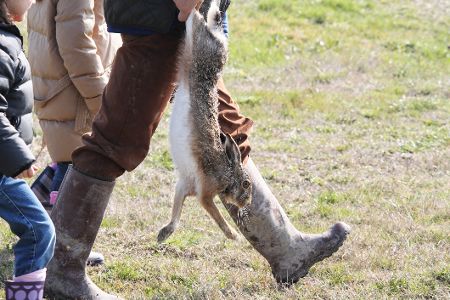 Jäger mit Gewehr und totem Hasen