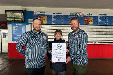 Das Catering-Team des Ostseestadions Rostock um Geschäftsführer Christoph Wulff (r) und Küchenchef Jens Schaumburg (l) hat das längste Fischbrötchen der Welt produziert. Bestätigt wurde der Rekord von Laura Koblischek (M) vom Rekord-Institut Deutschland. (Foto Handout)