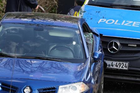 Das Auto steht zwischen zwei Polizeiautos und ist sichtlich beschädigt.