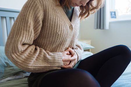 Frau hält sich vor Schmerzen den Bauch