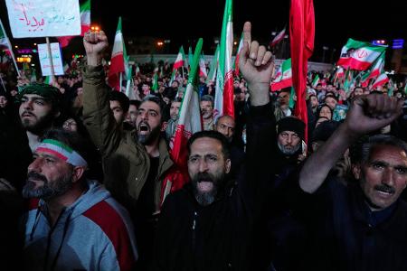 Regierungsanhänger feiern nach der Ankündigung der Waffenruhe in Teheran.
