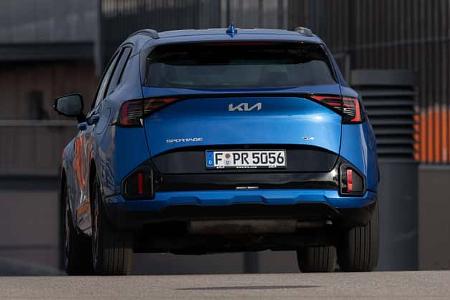 Kia Sportage 1,6 T-GDI AWD in blauer Lackierung, Heckansicht, aufgenommen in urbaner Umgebung.