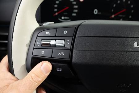 Detailaufnahme des Multifunktionslenkrads eines Kia Sportage 1,6 T-GDI AWD. Zu sehen sind Bedienelemente für Fahrassistenzsysteme und Drive Mode.