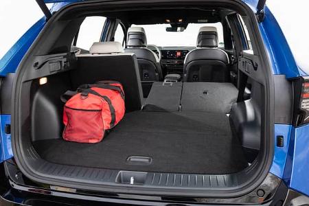 Kofferraumansicht eines Kia Sportage 1,6 T-GDI AWD mit umgeklappter Rückbank und roter Tasche im Laderaum.