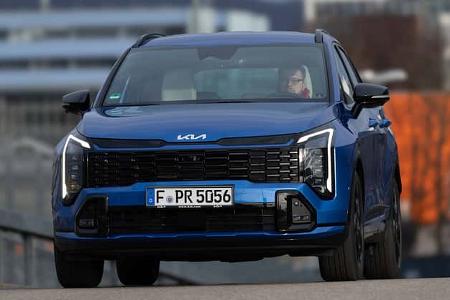 Frontansicht eines blauen Kia Sportage 1,6 T-GDI AWD in urbaner Umgebung, frontal fotografiert.