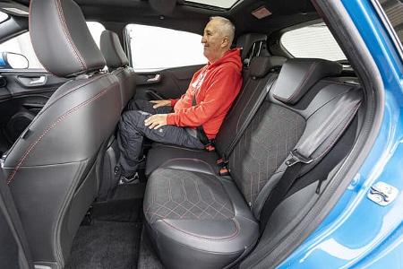 Innenraumaufnahme eines Ford Puma 1.0 EcoBoost mit einer Person auf der Rückbank. Sicht auf die Rücksitze, Vordersitze und Türverkleidungen.