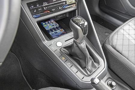 Detailaufnahme des Automatikwählhebels und der Mittelkonsole im VW Taigo 1,5 TSI. Sichtbar sind der Wählhebel für das Automatikgetriebe, Bedientasten, ein Smartphone-Fach sowie Teile der Klimasteuerung und des Fahrersitzes.