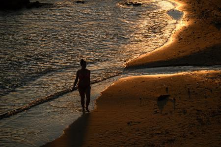 Spaziergang in der Abendsonne: Eine Person geht über den Sand am Milk Beach.