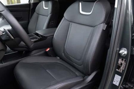 Vordersitze des Hyundai Tucson 1.6 T-GDI, fotografiert aus geöffneter Fahrertür, Fokus auf Sitzpolster und Innenraum.