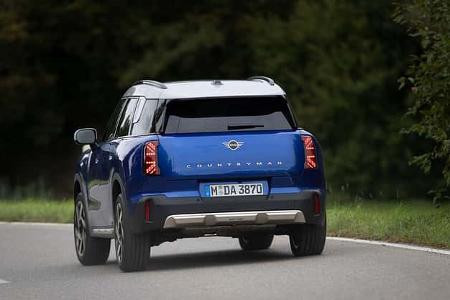 Der Dateiname 'Mini Countryman C 2,0-HDS-03.jpg' gibt eindeutig das Modell Mini Countryman C 2,0 an. Das Bild zeigt einen blauen Mini Countryman C 2,0 auf einer Landstraße aus der Heckperspektive. Die IPTC-Keywords bestätigen das Modell und die Straßenszene. Die visuelle Analyse stimmt mit diesen Angaben überein.